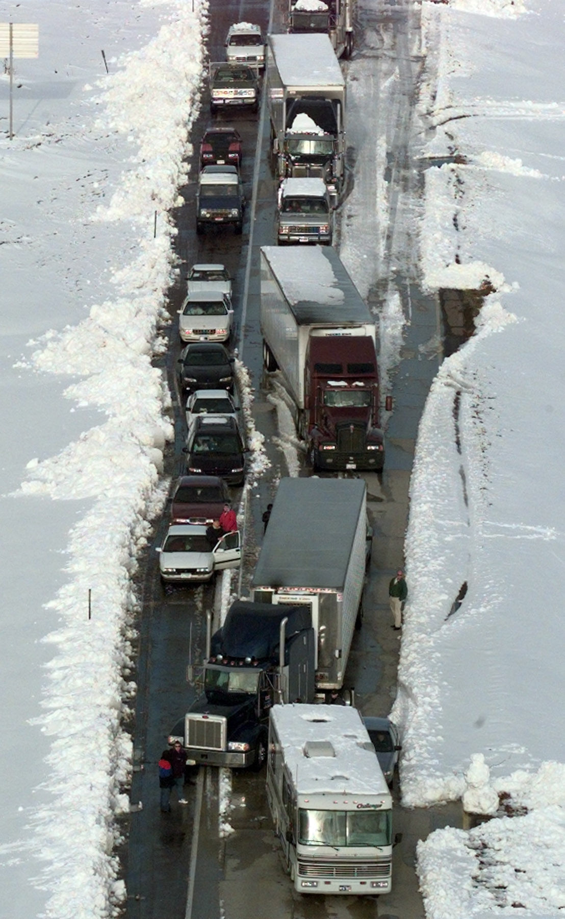 People stand out along their vehicles 3 miles west of the Greenwood interchange on Interstate 80 in the westbound lane. Approximately 7 to 8 miles of traffic was at a standstill as cars and trucks tried to negotiate one lane of the interstate west of this location.